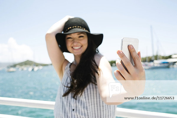 USA  Jungferninseln  Saint Thomas  Frau macht Selfie mit Bucht im Hintergrund