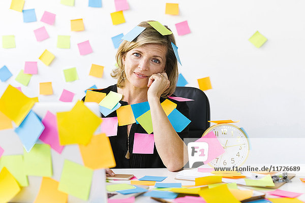 Portrait of Mature woman at office covered with adhesive notes