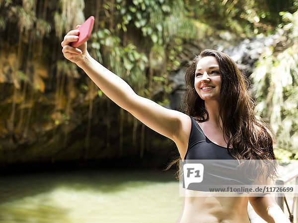 Caribbean Islands  Saint Lucia  woman taking selfie by waterfall