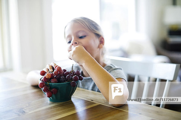 Junges Mädchen (6-7) isst frische Weintrauben