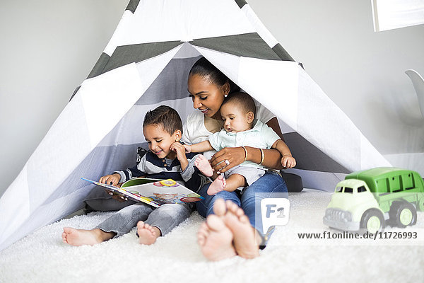 Mother playing with sons (2-5 months  2-3) in toy tent