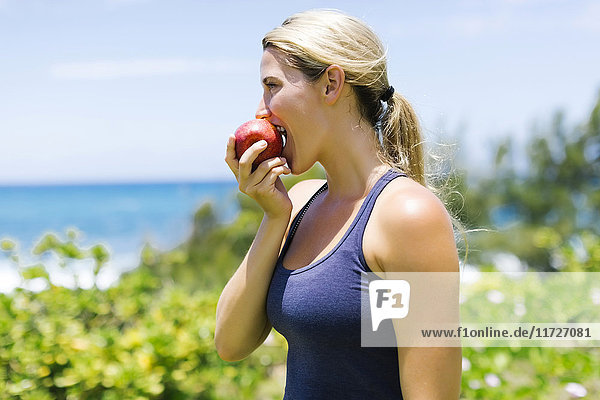 Blonde schöne Frau isst frischen Apfel