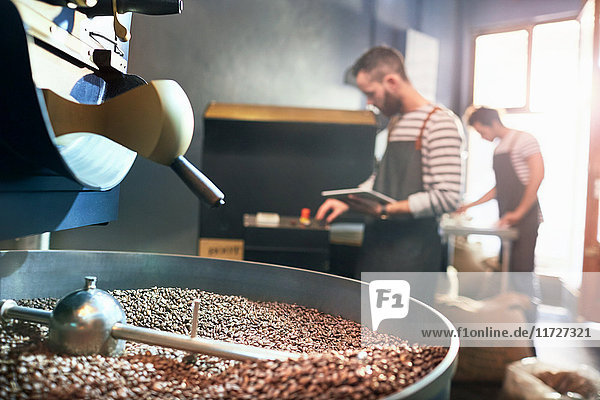 Male coffee roasters behind roasting coffee beans