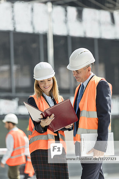 Architects reviewing paperwork at construction site