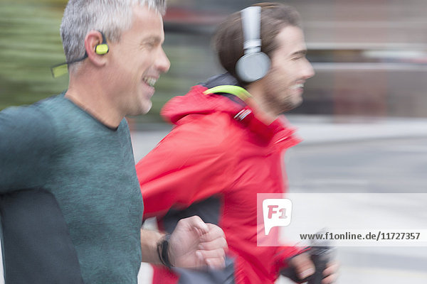 Lächelnde männliche Läufer mit laufendem Kopfhörer
