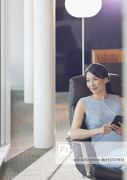 Businesswoman using cell phone in office lounge