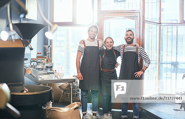 Portrait smiling coffee roasters in aprons