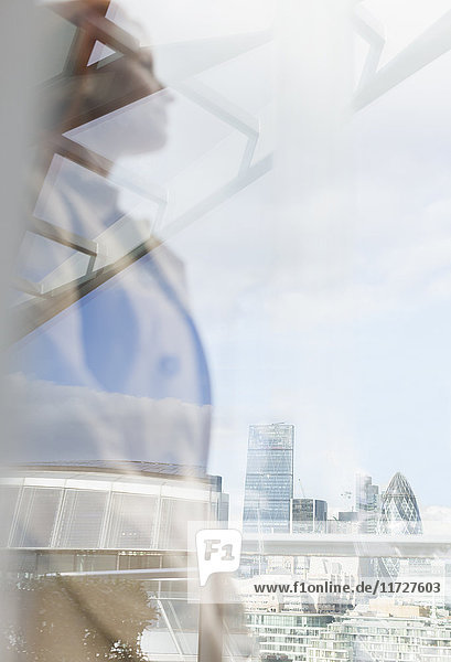 Nachdenkliche Geschäftsfrau mit Blick auf die Stadt vom Stadtbalkon  London  UK