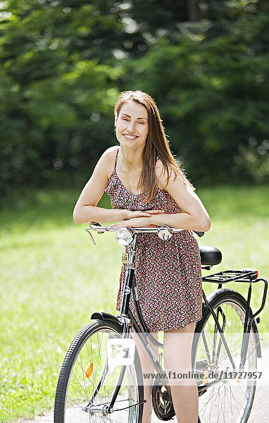 Hübsche Frau mit Fahrrad im Park