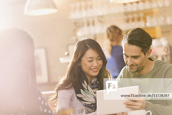 Freunde benutzen digitales Tablet im Café