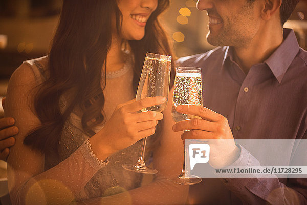 Verliebtes Paar stößt mit Champagnerflöten an