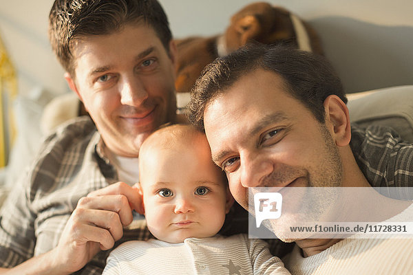 Portrait smiling male gay parents and cute baby son