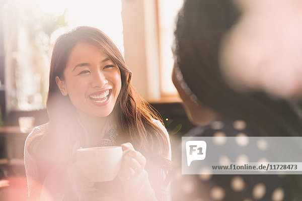 Lachende Frauen im Gespräch und beim Kaffeetrinken in einem Cafe
