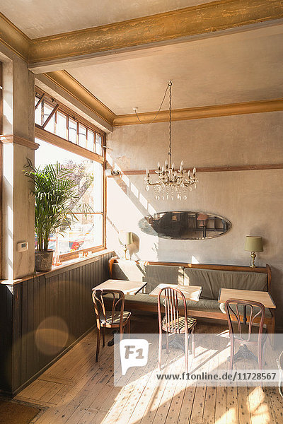 Wooden table with chairs and booth in empty vintage cafe