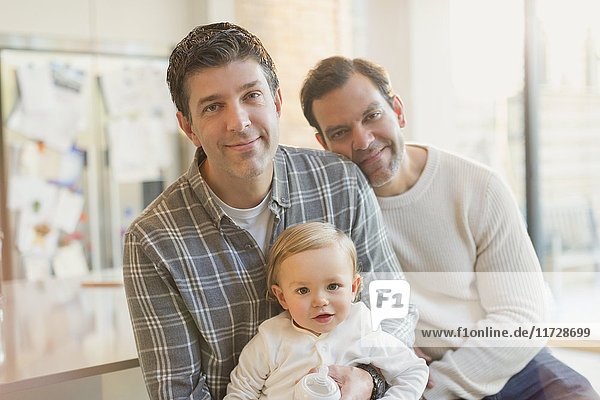 Portrait smiling male gay parents with baby son