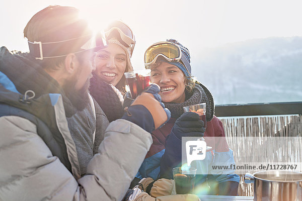 Lächelnde Skifahrerfreunde trinken Cocktails Apres-Ski