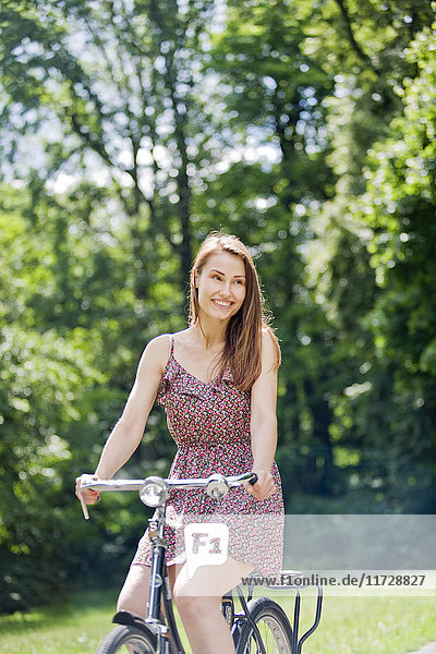 Hübsche Frau auf dem Fahrrad im Park.