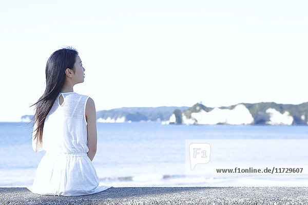 Junge Japanerin in einem weißen Kleid am Meer  Chiba  Japan