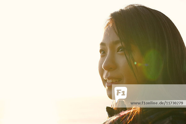 Young Japanese woman in a white dress at a cliff over the sea at sunrise  Chiba  Japan