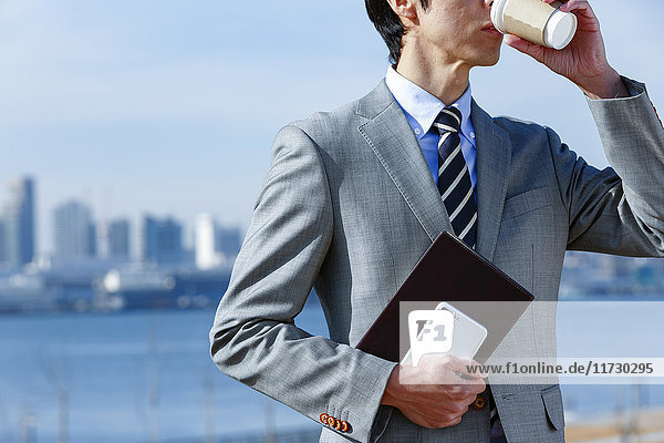 Japanischer Geschäftsmann mit Kaffee in der Innenstadt von Tokio  Japan