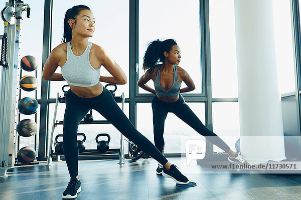 Two young women exercising in gym  doing aerobic workout