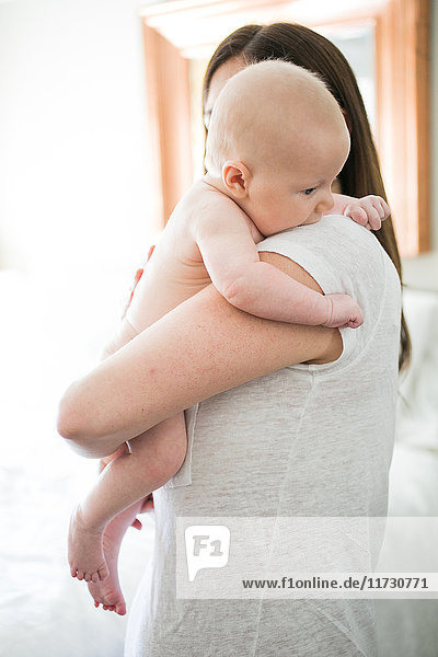 Mutter umarmt Baby Junge  Rückansicht