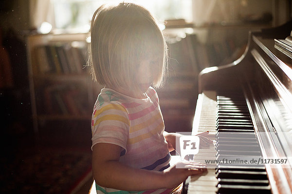 Mädchen zu Hause spielt altes Klavier
