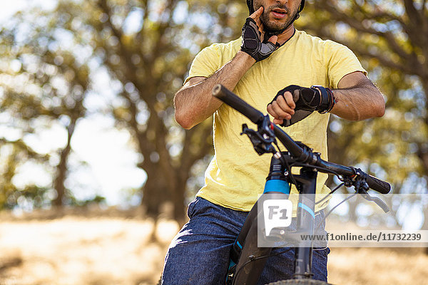 Cropped view of young male mountain biker checking smartwatch  Mount Diablo  Bay Area  California  USA