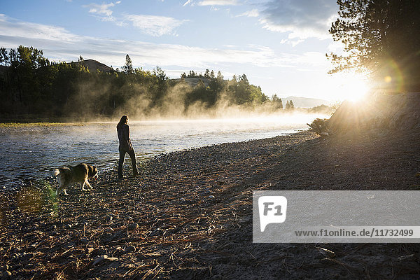 Frau beim Hundeausführen am Ufer des Bitterroot River  Missoula  Montana  USA