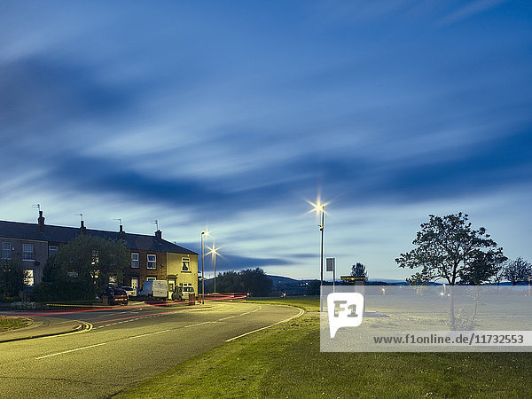 Lichtspuren auf der Straße bei Nacht in einem Wohngebiet