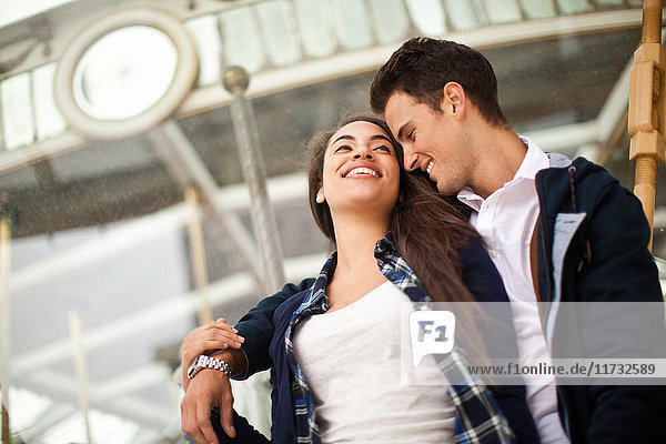 Young man with arm around woman  smiling
