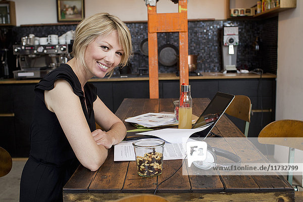 Mittlere erwachsene Frau im Café mit Papierkram