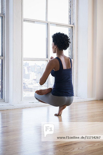 Frau praktiziert Yoga im Raum