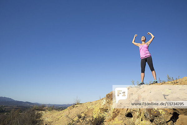 Mature female runner celebrating on top of hill  Thousand Oaks  California  USA