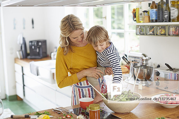 Mother and son in kitchen together  preparing food