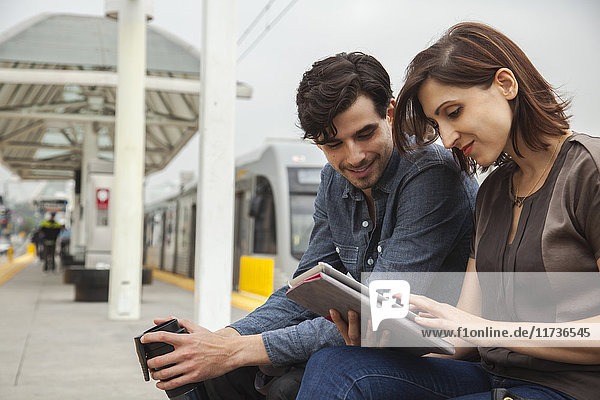 Ehepaar liest Zeitung  während es am Bahnhof wartet  Los Angeles  Kalifornien  USA