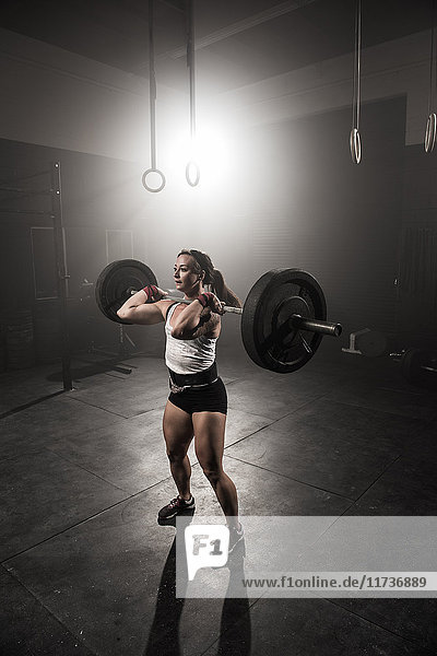 Young woman lifting barbell