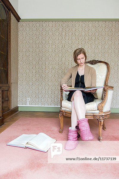 Tilburg  Netherlands. Portrait woman reading part of the Holy Bible while sitting in her reading room library chair.