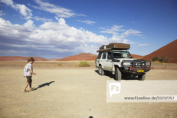 Boy walking to vehicle  Namib Naukluft National Park  Namib Desert  Sossusvlei  Dead Vlei  Africa