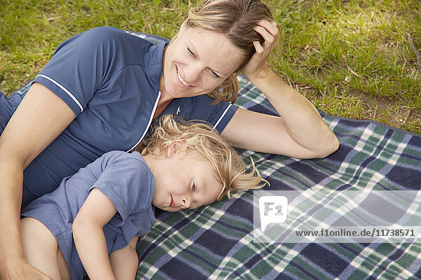 Mutter und Sohn liegen auf einer Picknickdecke