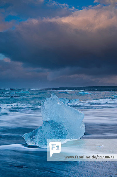 Eisberge am Strand und stürmischer Himmel,  Jokulsarlon,  Island