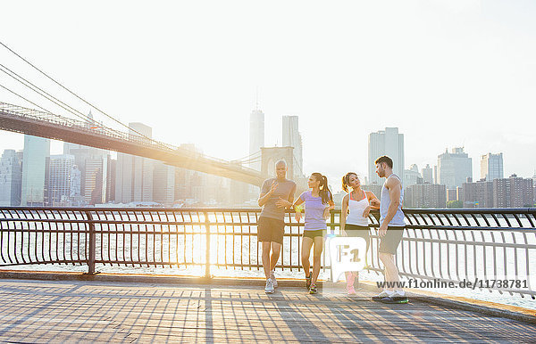 Junge erwachsene Läufer im Gespräch vor der Brooklyn Bridge  New York  USA