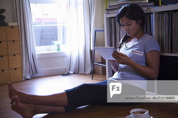 Young woman using digital tablet on floor