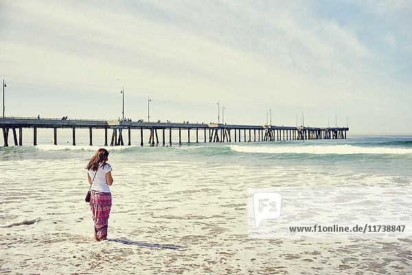Rückansicht einer Frau  die vor dem Pier paddelt  Venice Beach  Los Angeles  Kalifornien