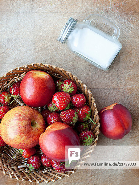 Korb mit Äpfeln  Pfirsichen und Erdbeeren  Draufsicht