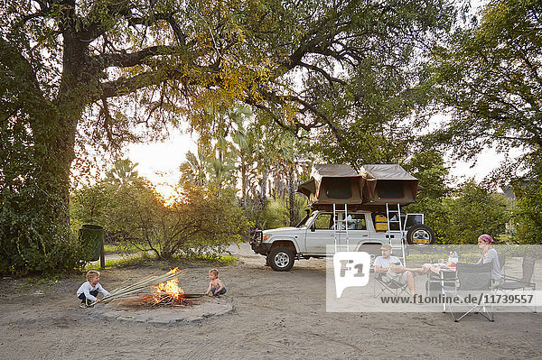 Geländewagen geparkt  Familie entspannt sich am Lagerfeuer  Nata  Makgadikgadi  Botswana