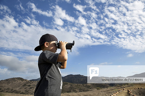 Boy looking out through binoculars  Thousand Oaks  California USA