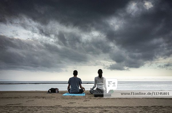 Young couple performing Yoga on Las Canteras beach just after sunrise. Las Palmas  Gran Canaria  Canary Islands  Spain .