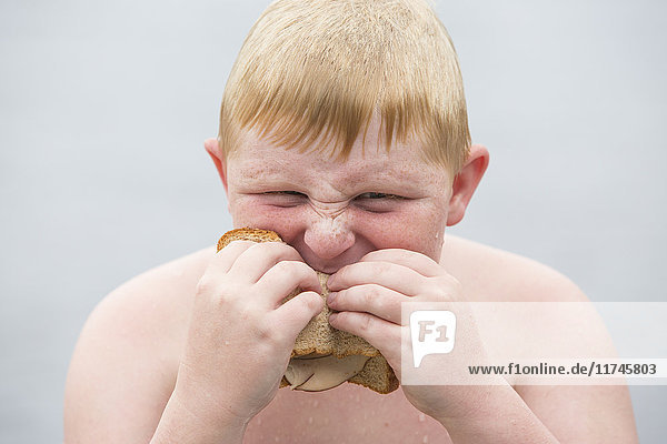 Porträt eines Jungen  der ein Sandwich isst