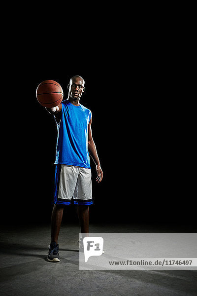 Studioporträt eines Basketballspielers  der den Ball hält
